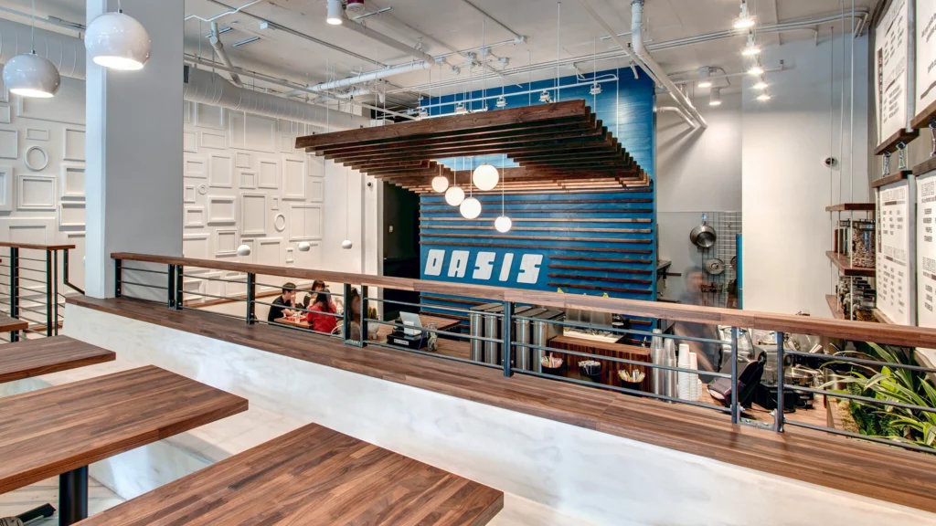 The interior of a coffee shop with wooden tables and chairs representing commercial new construction San Francisco.