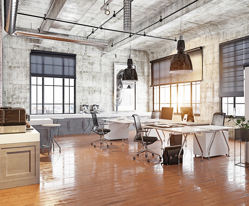 An example of commercial new construction highlighting an industrial style office with desks and chairs.