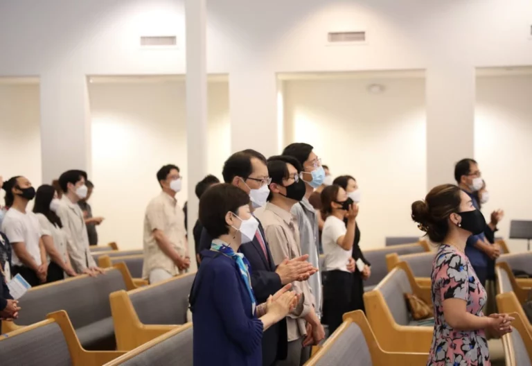 A group of people wearing face masks in a church built by an institutional contractor.