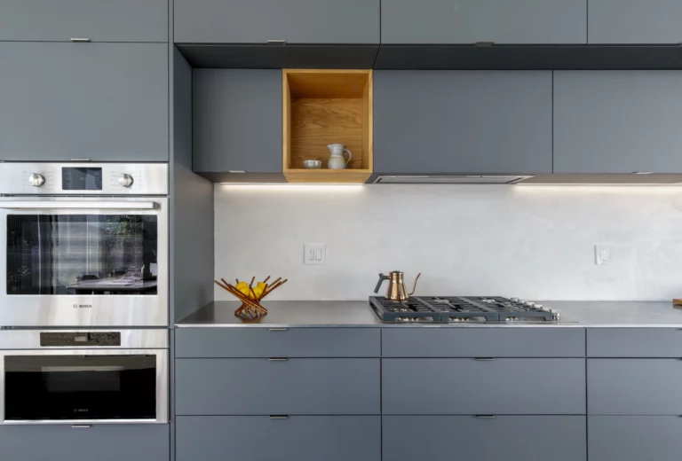 A multi-family dwelling kitchen with grey cabinets and an oven.