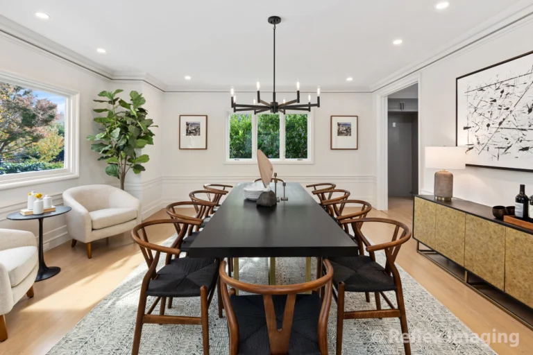 A dining room with a large table and chairs.