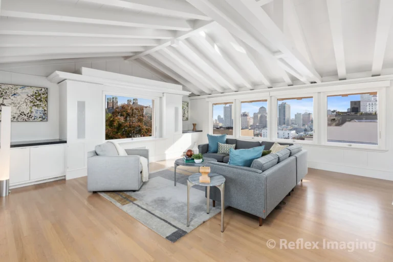 A living room with hardwood floors and a view of the city.